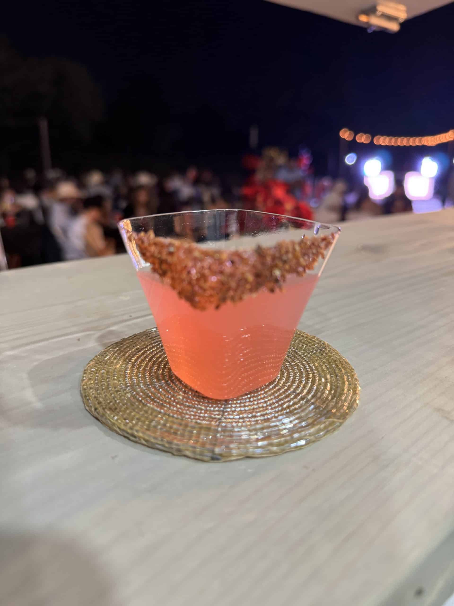 Guests celebrating at a private party under string lights, chili-lime rimmed cocktail in the foreground